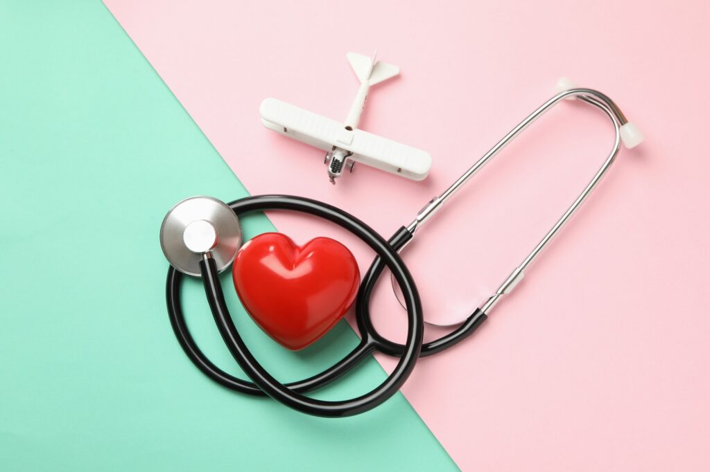 Stethoscope, heart and plane on two tone background